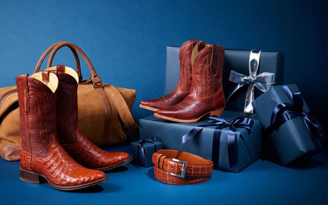 Three single boots from the Limited Edition Collection sitting on a pile of navy-wrapped gifts.
